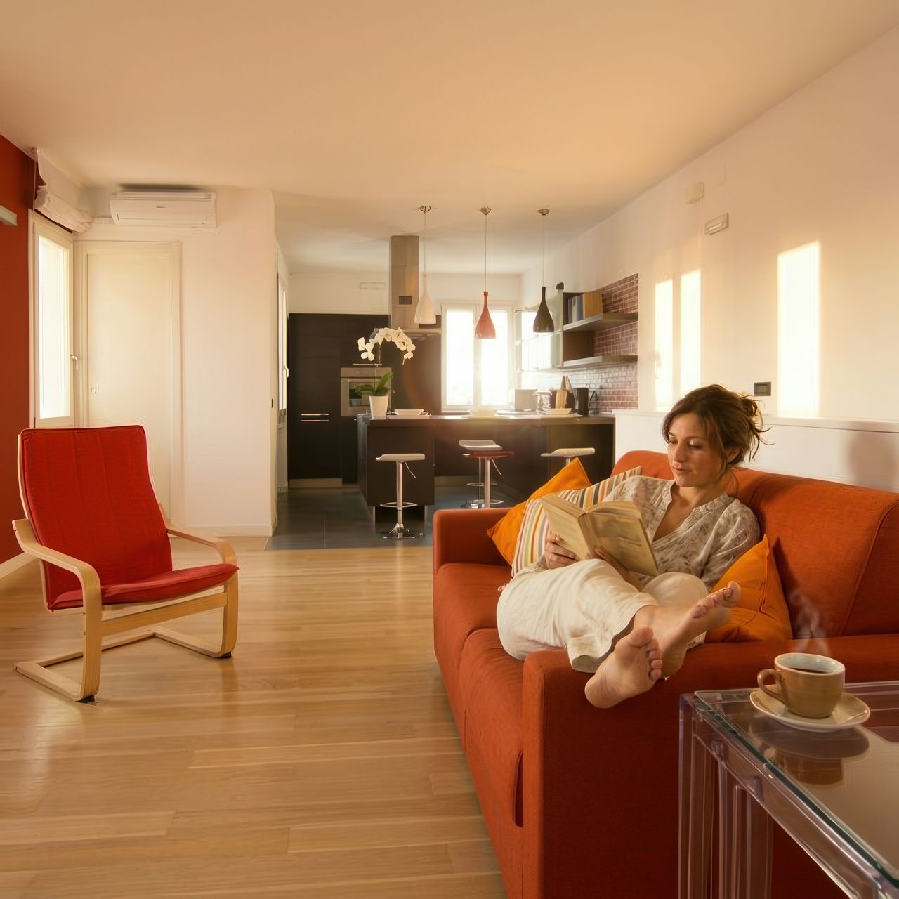 BRW House living room — relaxing on the sofa, morning light, kitchen in the background